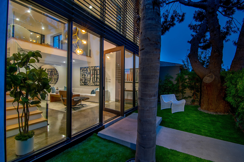 Exterior of a home with wood cladding, glass doors and landscaped planting