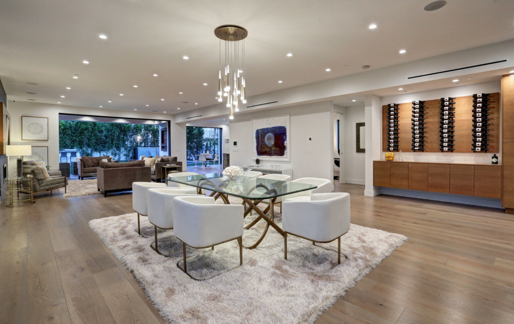 Open living room with neutral seating, large windows and a wood accent wall