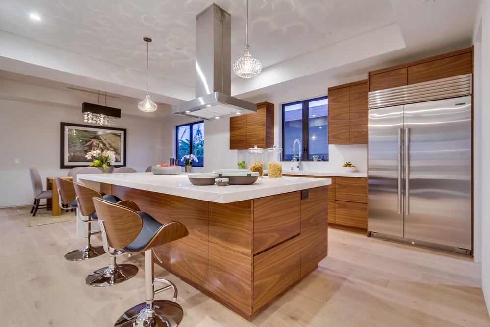 Open kitchen with warm wood cabinets and a white island