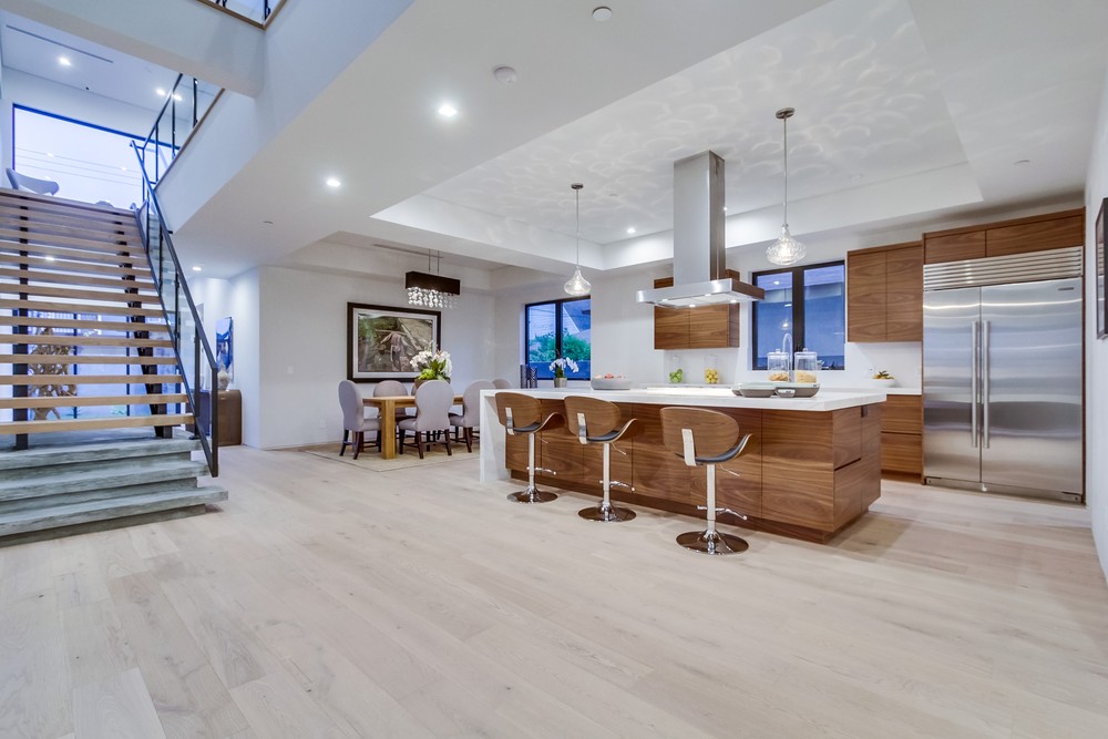 Open kitchen with wood cabinets, a white island and a connected dining area